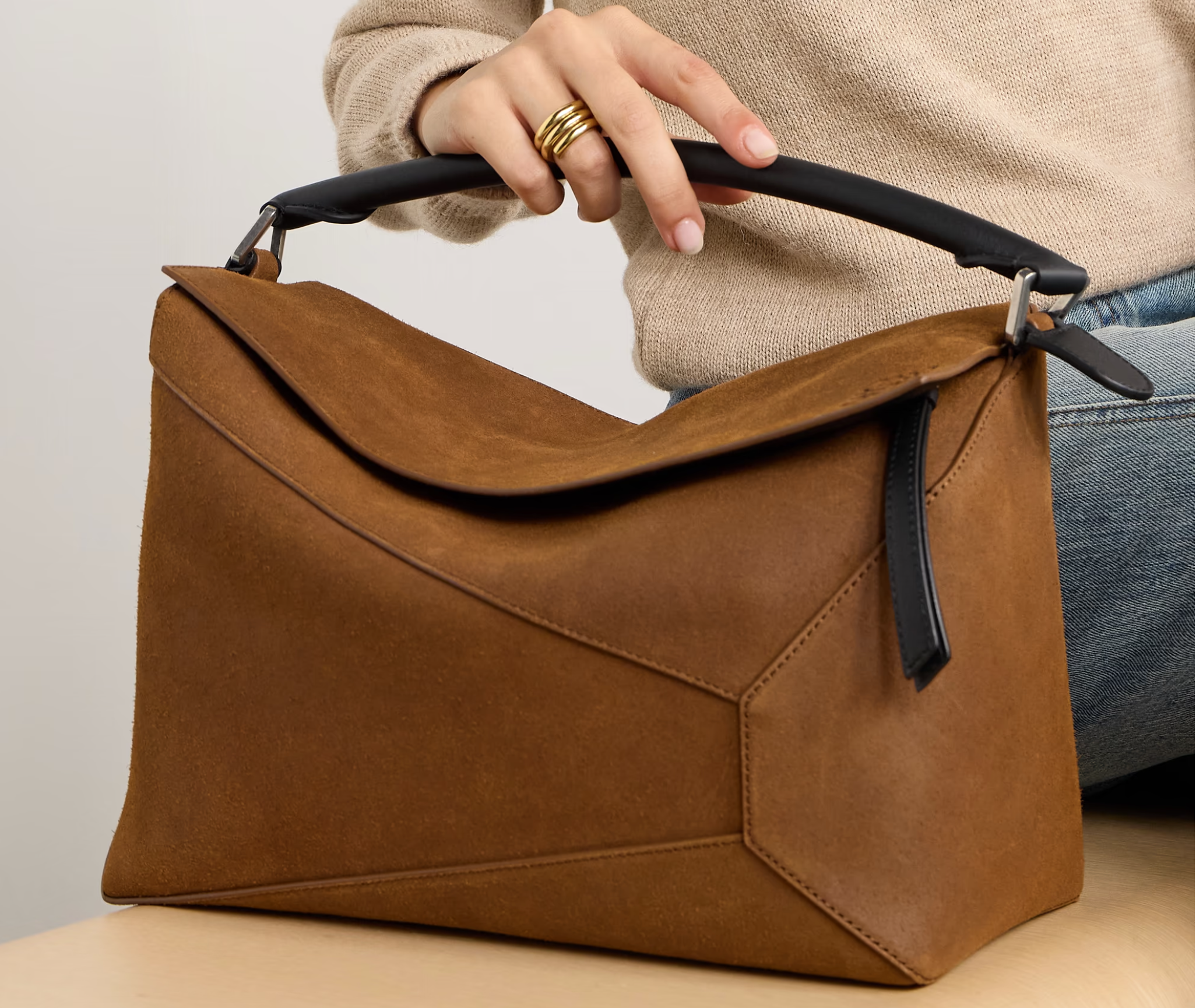 A chic Loewe Puzzle Bag in tan leather, featuring the brand's signature geometric design and versatile carrying options, perfect for adding sophistication to any outfit.